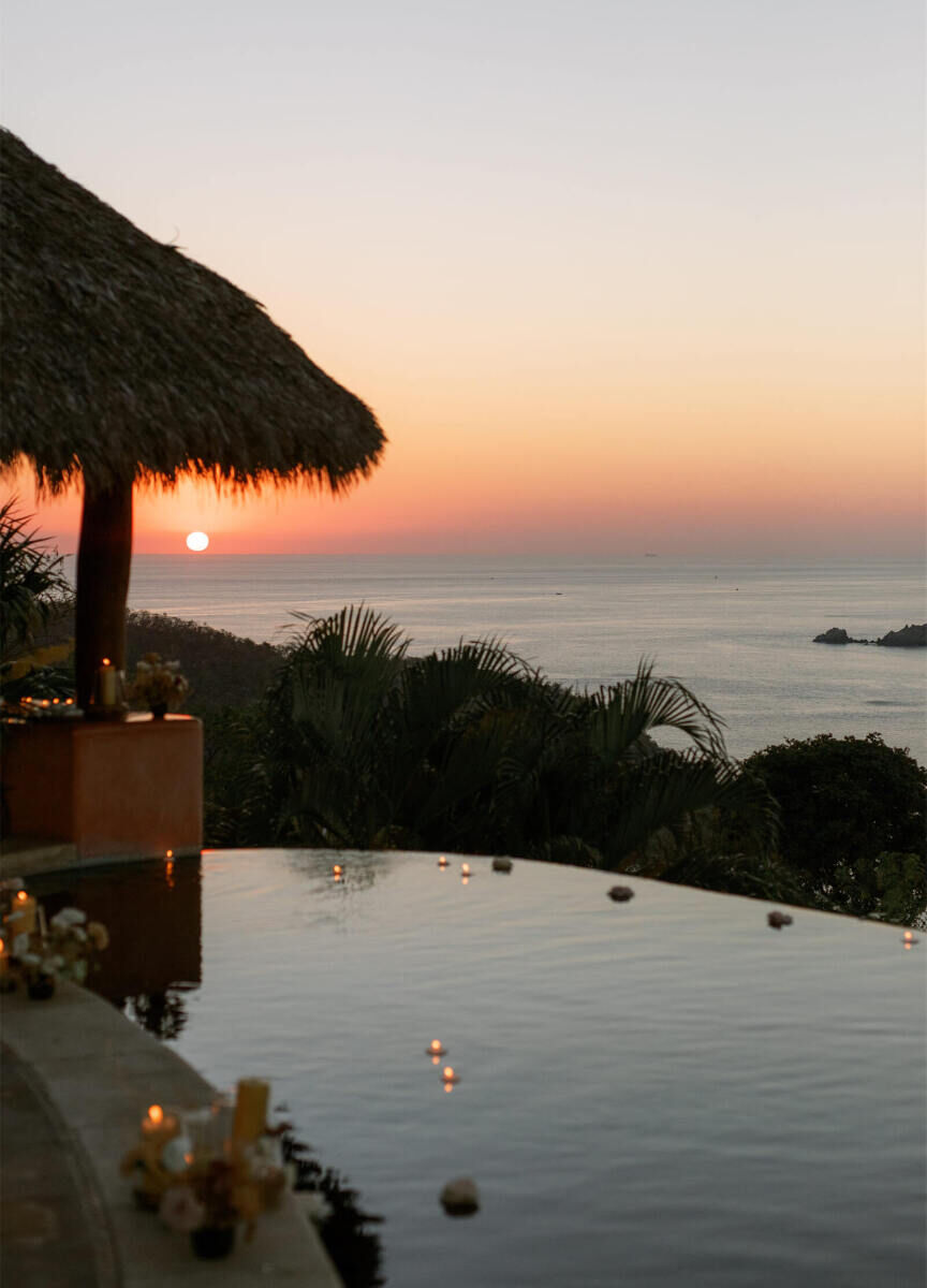 A sunset over Zihuatenejo Bay also reflects in the pool of Casa Angelina, a small, bohemian wedding venue.