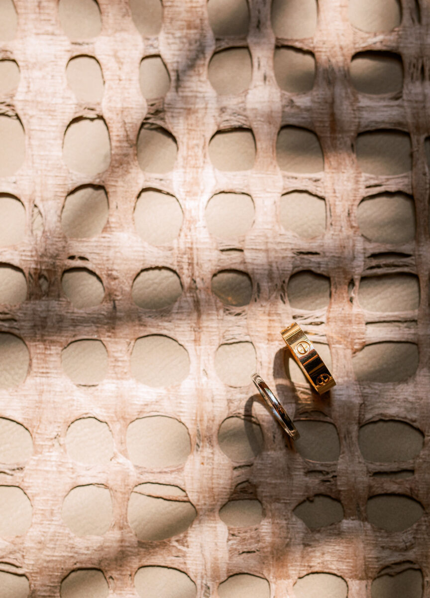 Light shines through palm trees to create a shadow on a pair of Cartier wedding bands at a wedding in Mexico.
